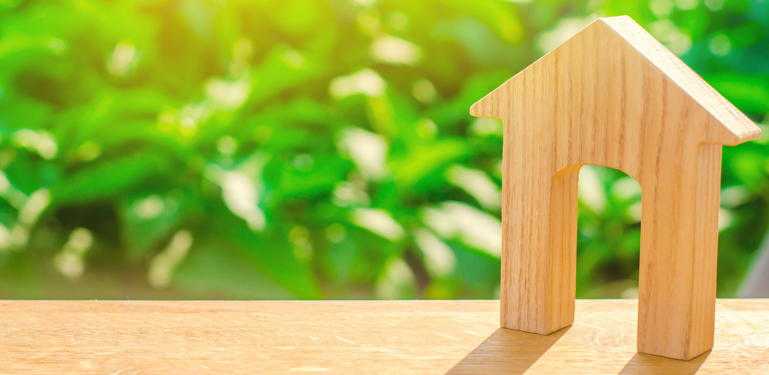 Figurine Of A Wooden House With A Large Doorway On A Green Backg